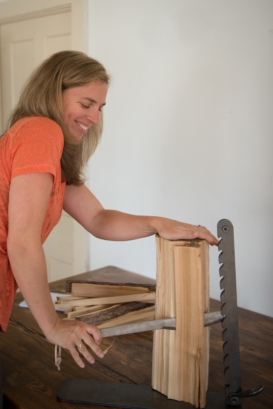 Lady using a kindling wood splitter called The Beaver Lever. 